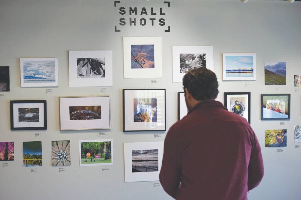 Alex Rydlinski, executive director of the Kenai Art Center, sets up the Small to Biggs photography show at the Kenai Art Center on Wednesday, March 2, 2022, in Kenai, Alaska. (Camille Botello/Peninsula Clarion)
