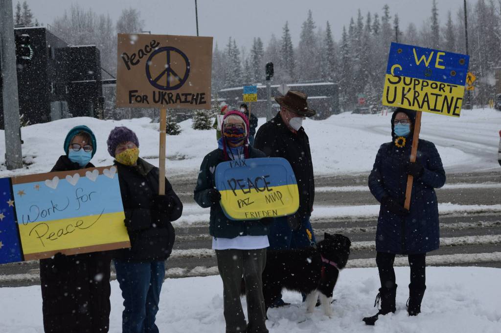 From left to right: Elaine Larson, Judy Johnson, Susie Smalley, Larry Simmons, Trixi the dog and Michele Vasquez demonstrate during the Many Voices Ukraine vigil on Saturday, March 5, 2022, in Soldotna, Alaska. (Camille Botello/Peninsula Clarion)