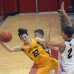 Ninilchiks Justin Trail saves the ball in front of Kenai Centrals Luke Armstrong and Eli McCubbins on Saturday, March 5, 2022, at Kenai Central High School in Kenai, Alaska. (Photo by Jeff Helminiak/Peninsula Clarion)