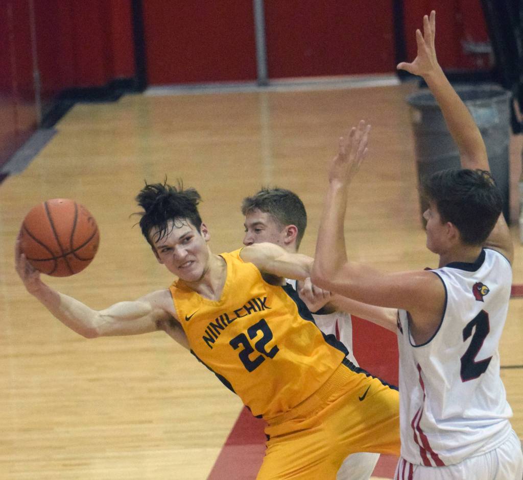 Ninilchiks Justin Trail saves the ball in front of Kenai Centrals Luke Armstrong and Eli McCubbins on Saturday, March 5, 2022, at Kenai Central High School in Kenai, Alaska. (Photo by Jeff Helminiak/Peninsula Clarion)