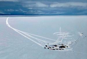 In this aerial photo provided by Alaska State Troopers, an Alaska Air National Guard helicopter arrives at a frozen lake that was the scene of a small plane crash on Saturday, March 5, 2022, near Iliamna, Alaska. Authorities say the five people on board the plane were injured. (Trooper Travis Lons/Alaska State Troopers via AP)