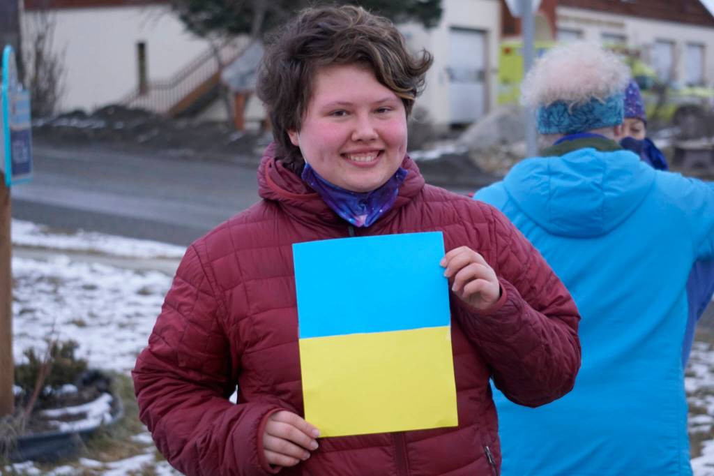 Alexis Schneider holds a homemade flag in support of Ukraine at a demonstration on Thursday, March 3, 2022, at WKFL Park in Homer, Alaska. (Photo by Michael Armstrong/Homer News)
