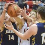 Kenai Central's Bridger Beck battles Homer's Ryan Carroll and Noah Irons for the ball Thursday, March 10, 2022, at the Peninsula Conference tournament at Kenai Central High School in Kenai, Alaska. (Photo by Jeff Helminiak/Peninsula Clarion)