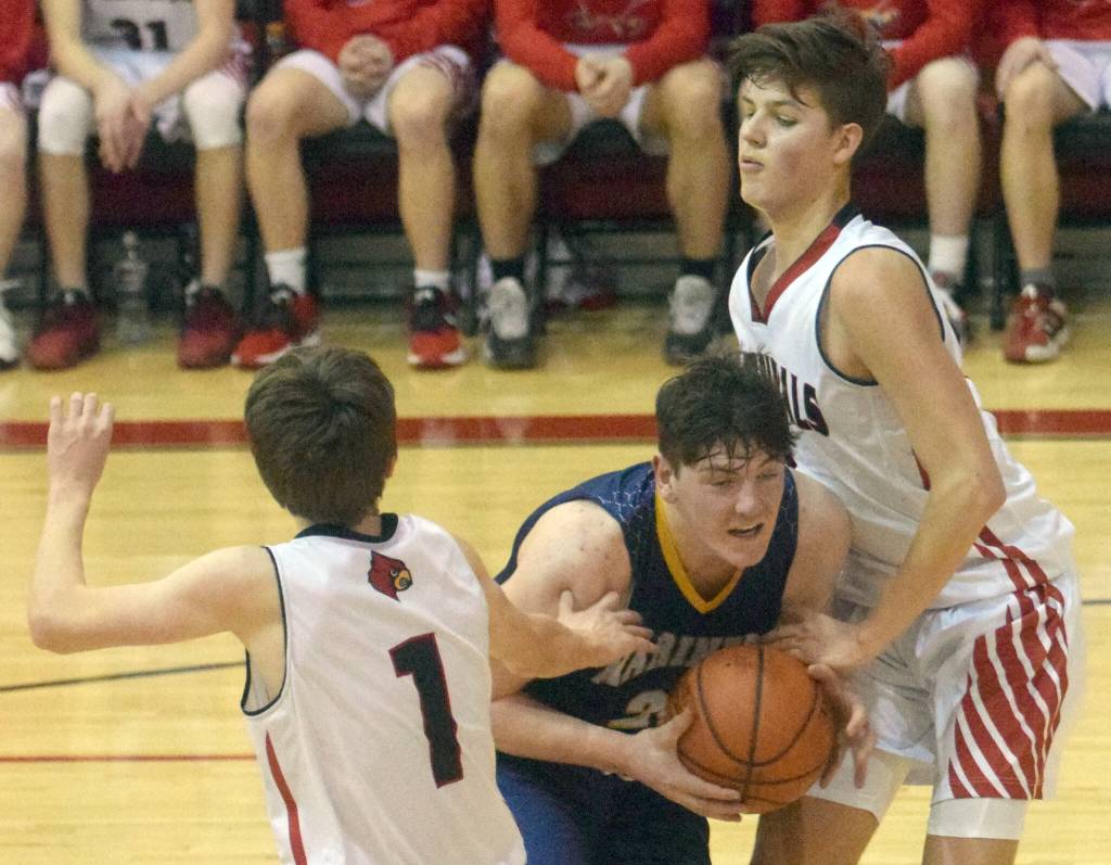 Homers Carter Tennison splits Kenai Centrals Ky Calvert and Eli McCubbins on Saturday, March 12, 2022, at the Peninsula Conference tournament at Kenai Central High School in Kenai, Alaska. (Photo by Jeff Helminiak/Peninsula Clarion)