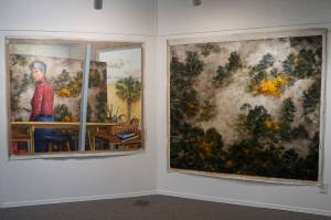 Selected Works and Sketches by Gaye Wolfe, showing at the Homer Council on the Arts through March, includes these two paintings by Wolfe: a painting of a wildfire, right, and then a self-portrait of Wolfe, left, creating the painting. (Photo by Michael Armstrong/Homer News)