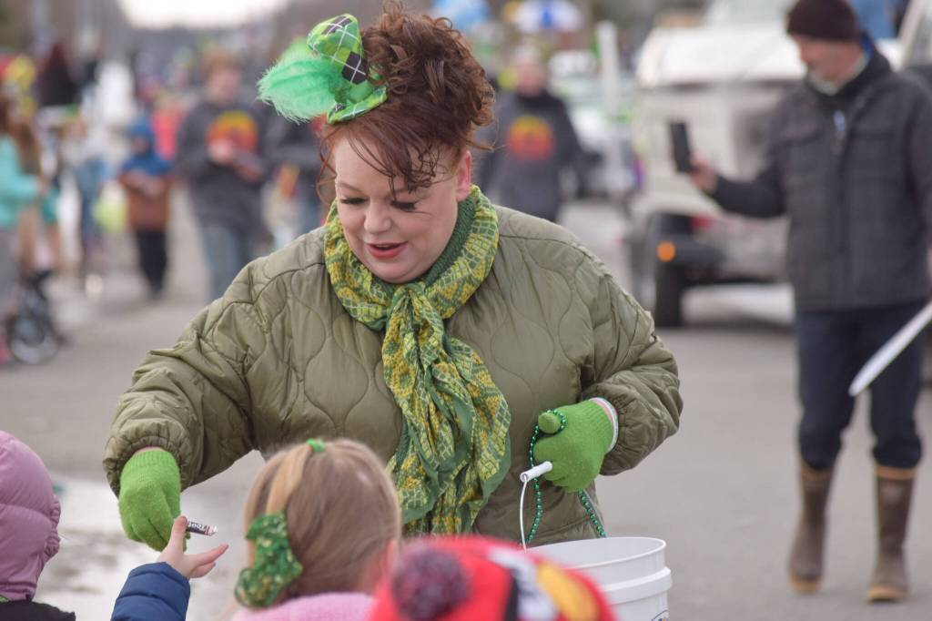 Shanon Davis, the executive director of the Soldotna Chamber of Commerce, hands out candy during the Sweenys St. Patricks Parade in Soldotna on March 17, 2022. (Camille Botello/Peninsula Clarion)