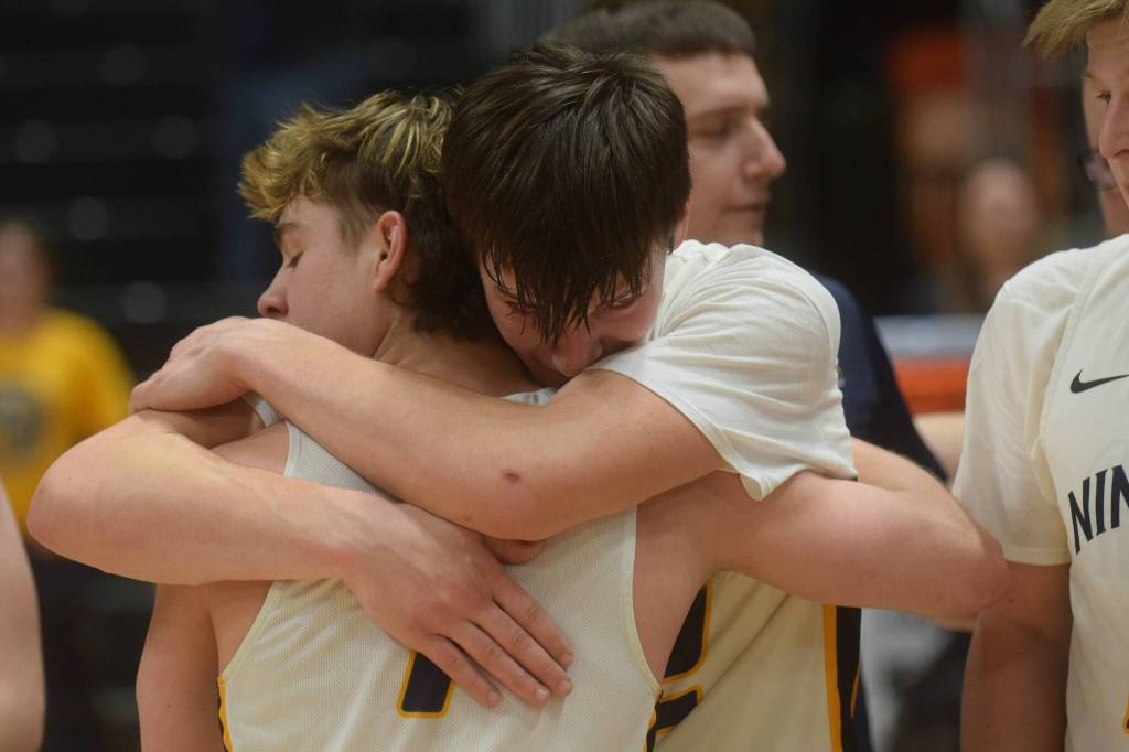 Justin Trail embraces Landon Colburn after the Ninilchik Wolverines won the Class 2A state basketball championship game at the Alaska Airlines Center in Anchorage, Alaska, on Saturday, March 19, 2022. (Camille Botello/Peninsula Clarion)