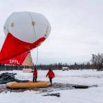 This Feb. 21, 2022, photo provided by the University of Alaska Fairbanks Geophysical Institute shows Swiss team members working with a tethered balloon and payload used to measure different characteristics of aerosols and trace gases in the atmosphere over Fairbanks, Alaska. Over seven weeks this winter, nearly 50 scientists from the continental U.S. and Europe descended on Fairbanks to study the sources of air pollution. (Daniel Walker/University of Alaska Fairbanks Geophysical Institute via AP)