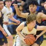 Homers Braden Huffman drives past Barrows Sika Unutoa during the Class 3A boys basketball fourth-place semifinals at the Alaska Airlines Center in Anchorage, Alaska, on Thursday, March 24, 2022. (Camille Botello/Peninsula Clarion)