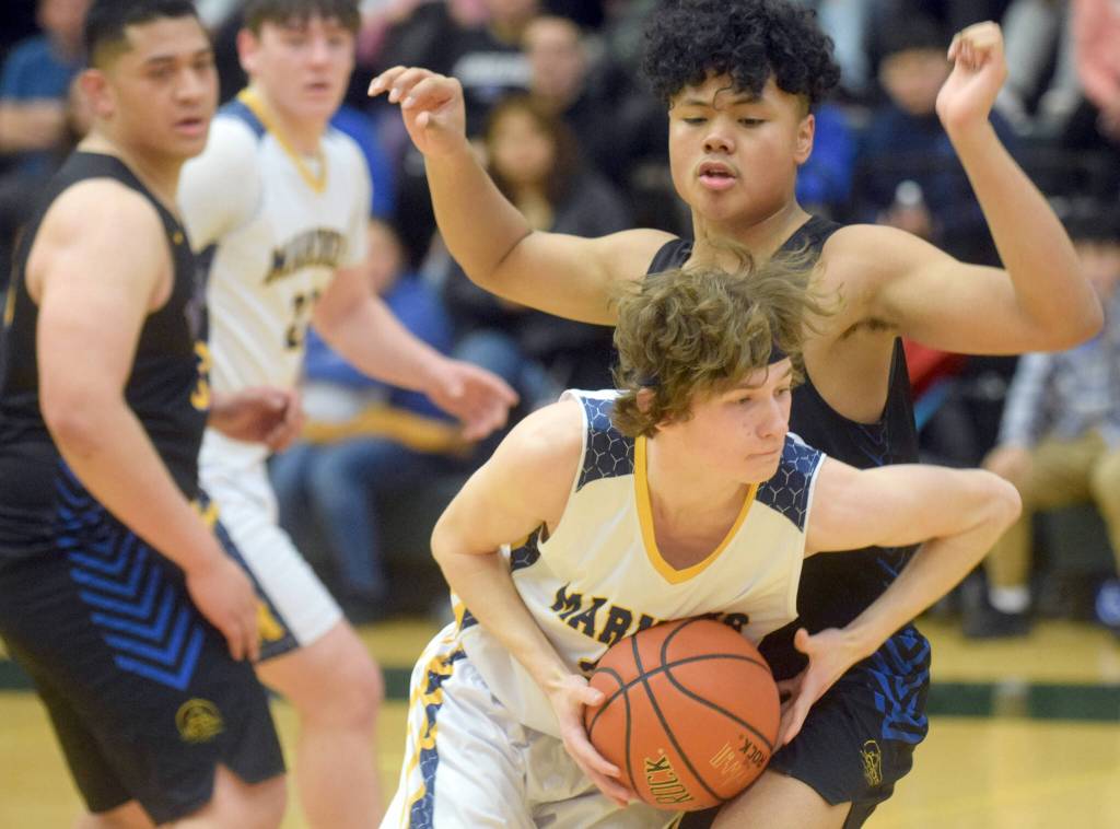 Homers Braden Huffman drives past Barrows Sika Unutoa during the Class 3A boys basketball fourth-place semifinals at the Alaska Airlines Center in Anchorage, Alaska, on Thursday, March 24, 2022. (Camille Botello/Peninsula Clarion)