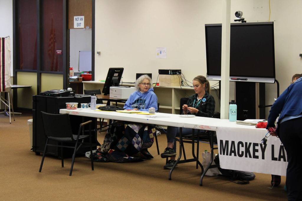 Teressa Minnich, left, speaks to another poll worker at a precinct at Soldotna Prep School on Tuesday, Oct. 5, 2021, in Soldotna, Alaska. (Ashlyn OHara/Peninsula Clarion)