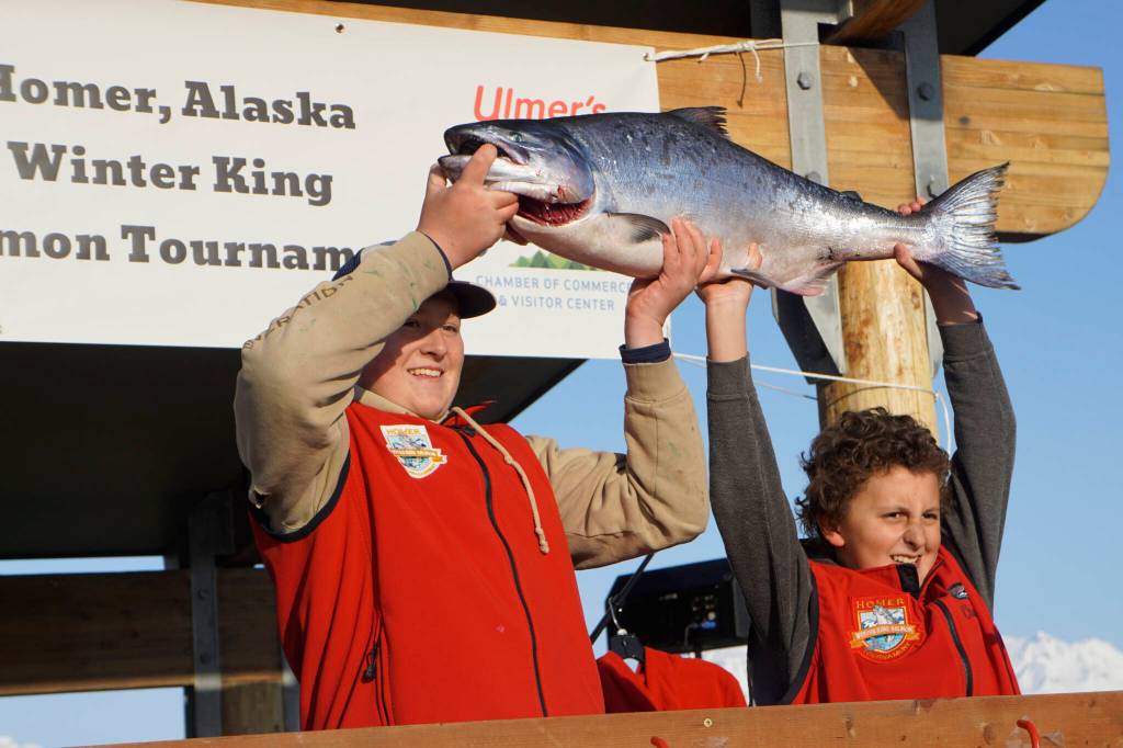 Weston Marley, left, holds up the 27.38-pound winter king salmon he caught to win the 28th annual Homer Winter King Salmon Tournament on Sunday, April 10, 2022, in Kachemak Bay, Homer, Alaska. At right is last years champion and Westons brother, Andrew Marley, 11  the youngest angler ever to win the tournament. Weston Marley, 15, fished on the Fly Dough with his father, Jay Marley. (Photo by Michael Armstrong/Homer News)