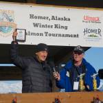 Jay Marley, left, captain of the Fly Dough, holds up the John Hillstrand Memorial Award for running the boat that had the winning fish in the 28th annual Homer Winter King Salmon Tournament. Homer Chamber of Commerce and Visitor Center executive director Brad Anderson is at right. Marleys son, Weston Marley, won the top prize with a 27.38-pound king salmon. Jay Marley also was the top captain in 2021 when his son Andrew also won the tournament. (Photo by Michael Armstrong/Homer News)