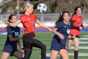 Kenai Central's Cali Holmes tries to clear the ball from Soldotna's Caleigh Glassmaker and Caylee Uribe-Koivisto on Thursday, April 14, 2022, at Soldotna High School in Soldotna, Alaska. (Photo by Jeff Helminiak/Peninsula Clarion)