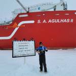 Michael Patz, raised in Juneau, stands on the ice in front of the icebreaker S.A. Agulhas II next to a sign showing the location of the wreck of Ernest Shackletons vessel, the Endurance, in this March 2022 photo. The ship was rediscovered March 5, 2022, by searchers aboard the icebreaker. (Courtesy photo/Michael Patz)