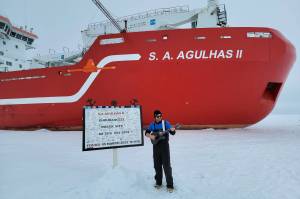 Michael Patz, raised in Juneau, stands on the ice in front of the icebreaker S.A. Agulhas II next to a sign showing the location of the wreck of Ernest Shackletons vessel, the Endurance, in this March 2022 photo. The ship was rediscovered March 5, 2022, by searchers aboard the icebreaker. (Courtesy photo/Michael Patz)