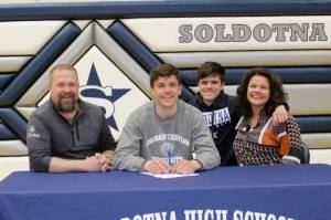 Nate Johnson signs his National Letter of Intent on Friday, April 22, 2022, at Soldotna High School in Soldotna, Alaska. From left to right are Nate's father, Eric; Nate; Nate's brother, Wesley; and Nate's mother, Meghan. (Photo provided)
