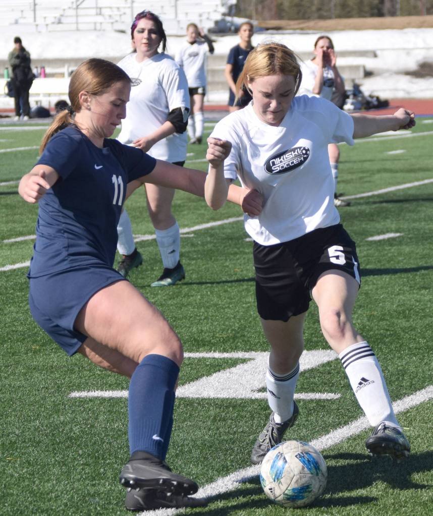 Soldotnas Sadie Lane and Nikiskis Dani Thies battle for the ball Wednesday, April 27, 2022, at Justin Maile Field at Soldotna High School in Soldotna, Alaska. (Photo by Jeff Helminiak/Peninsula Clarion)