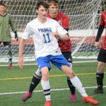Palmer's Xander Logan plays the ball back in front of Kenai Central's Bridger Beck and Daniel Shelden on Friday, April 29, 2022, at Kenai Central High School in Kenai, Alaska. (Photo by Jeff Helminiak/Peninsula Clarion)