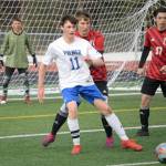 Palmers Xander Logan plays the ball back in front of Kenai Centrals Bridger Beck and Daniel Shelden on Friday, April 29, 2022, at Kenai Central High School in Kenai, Alaska. (Photo by Jeff Helminiak/Peninsula Clarion)