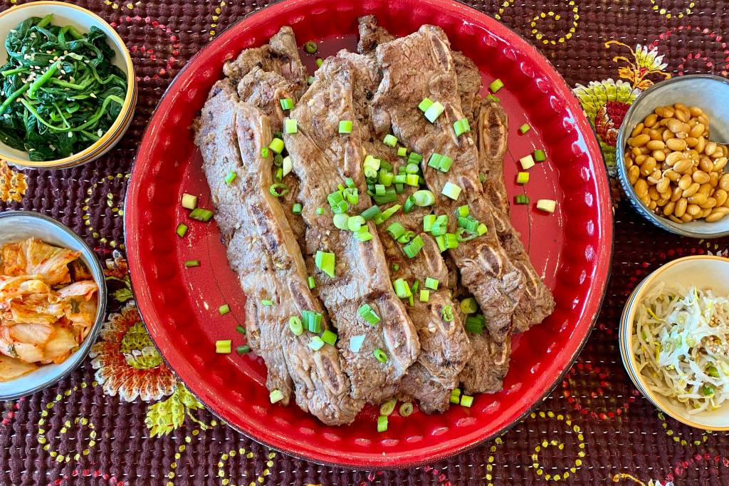 Kalbi ribs can be served with an assortment of side dishes, including white rice, kimchi, roasted garlic cloves, broccoli salad, dumplings and soup. (Photo by Tressa Dale/Peninsula Clarion)