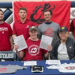 Wayne Mellon, seated at the table with stepfather Michael Gebhard, signs a National Letter of Intent on Tuesday, May 4, 2022, at Soldotna High School in Soldotna, Alaska. In back are SoHi wrestling coaches Aaron Gordon, Logan Parks, Neldon Gardner and Pete Dickinson. (Photo provided)
