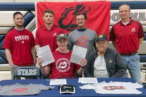Wayne Mellon, seated at the table with stepfather Michael Gebhard, signs a National Letter of Intent on Tuesday, May 4, 2022, at Soldotna High School in Soldotna, Alaska. In back are SoHi wrestling coaches Aaron Gordon, Logan Parks, Neldon Gardner and Pete Dickinson. (Photo provided)