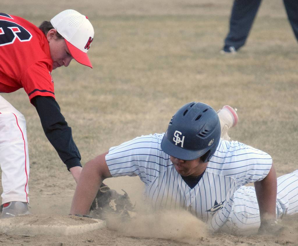 Soldotnas Atticus Gibson slides in safely in front of the tag of Kenai Central first baseman Xander Amend at the Soldotna Little League fields Wednesday, May 4, 2022, in Soldotna, Alaska. (Photo by Jeff Helminiak/Peninsula Clarion)