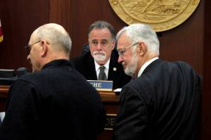 Alaska state Senate President Peter Micciche, center, looks on as lawmakers gather in front of him on the Senate floor on Wednesday, May 4, 2022, in Juneau, Alaska. A bill dealing with the annual dividend paid to residents was bumped from the Senate floor on Wednesday. Micciche said it did not have the votes to pass. (AP Photo/Becky Bohrer)