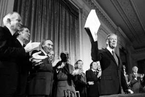 President Jimmy Carter holds up the Alaska National Interest Lands Conservation Act, which declared 104 million acres in Alaska as national parks, wildlife refuges and other conservation categories, after signing it into law at a ceremony at the White House in Washington, on Dec. 2, 1980. Carter on Monday, May 9, 2022, took the unusual step of weighing in on a court case involving his landmark conservation act and a remote refuge in Alaska. Carter filed a amicus brief in the longstanding legal dispute over efforts to build a road through the refuge, worried that the latest decision to allow a gravel road to provide residents access to an all-weather airport for medical evacuations goes beyond this one case and could allow millions of acres (hectares) to be opened for adverse development. (AP Photo, File)