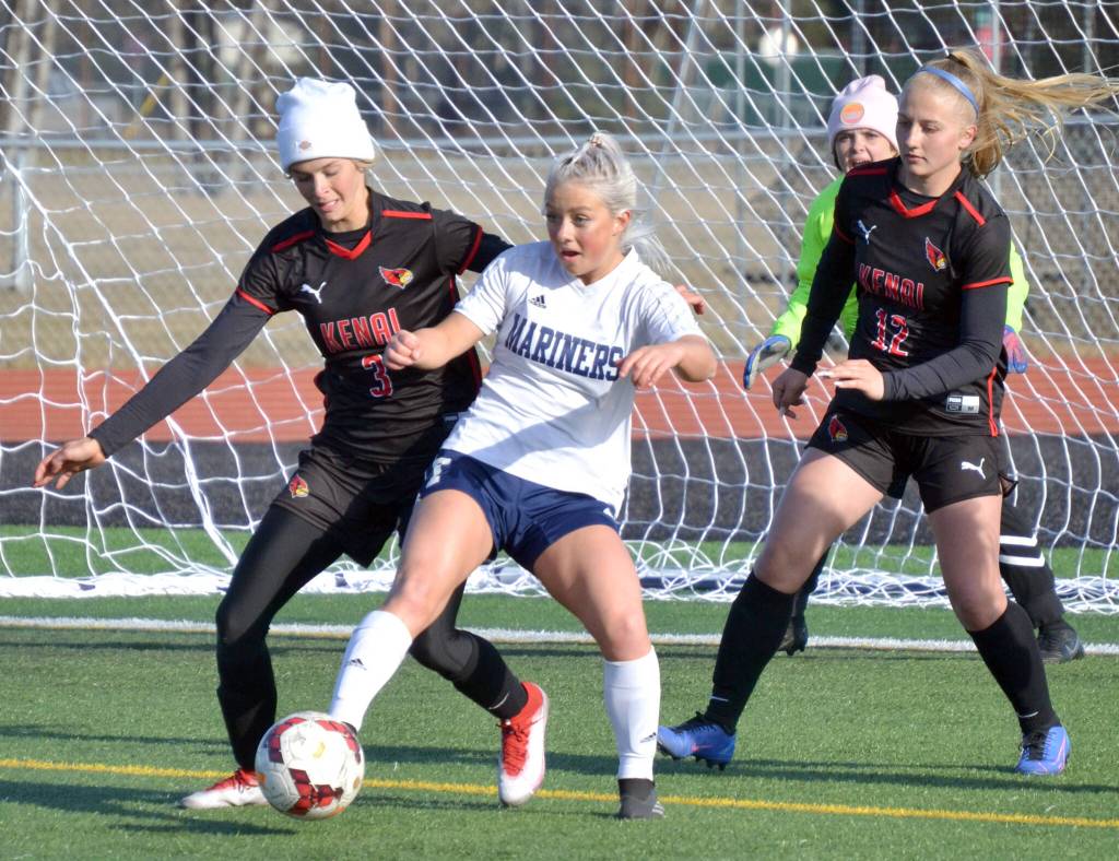 Homers Sela Weisser shields the ball from Kenai Centrals Cali Holmes and Kate Wisnewski before notching an assist Tuesday, May 10, 2022, at Ed Hollier Field at Kenai Central High School in Kenai, Alaska. (Photo by Jeff Helminiak/Peninsula Clarion)