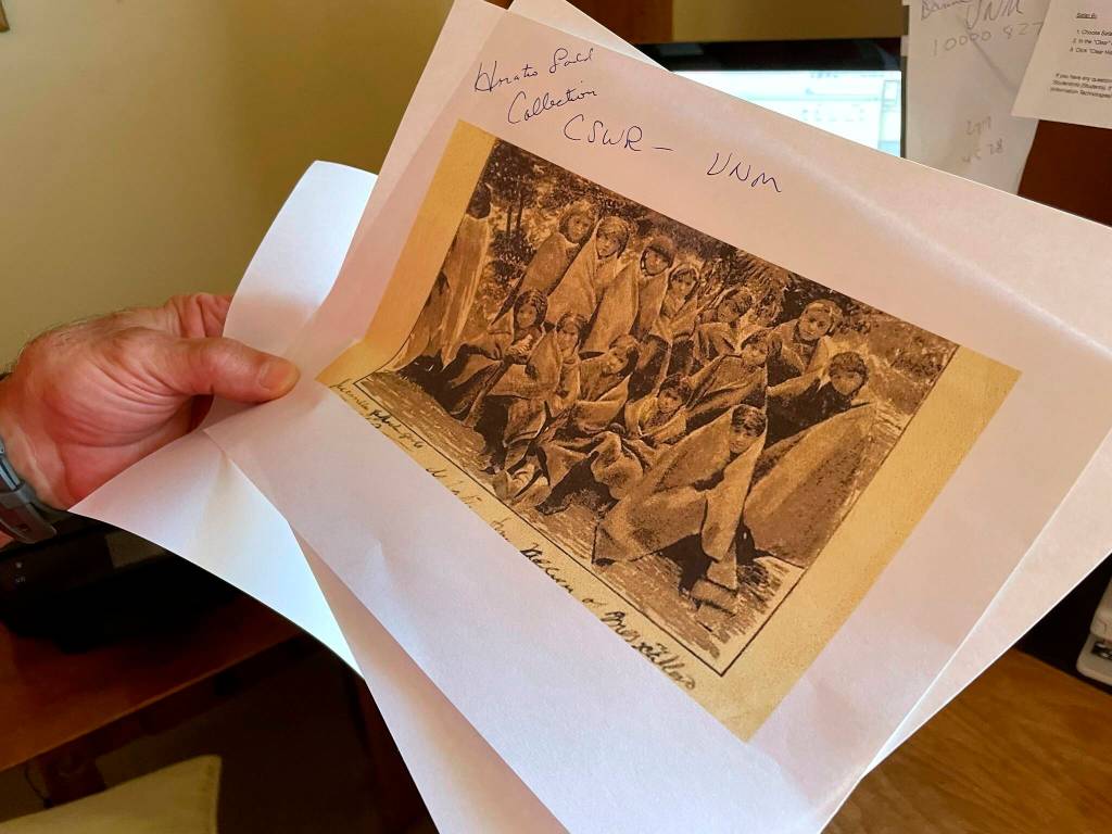 In this July 8, 2021, photo, adjunct history professor and research associate Larry Larrichio holds a copy of a late 19th century photograph of pupils at an Indigenous boarding school in Santa Fe during an interview in Albuquerque, New Mexico. The U.S. Interior Department is expected to release a report Wednesday, May 11, 2022, that it says will begin to uncover the truth about the federal governments past oversight of Native American boarding schools. (AP Photo/Susan Montoya Bryan, File)