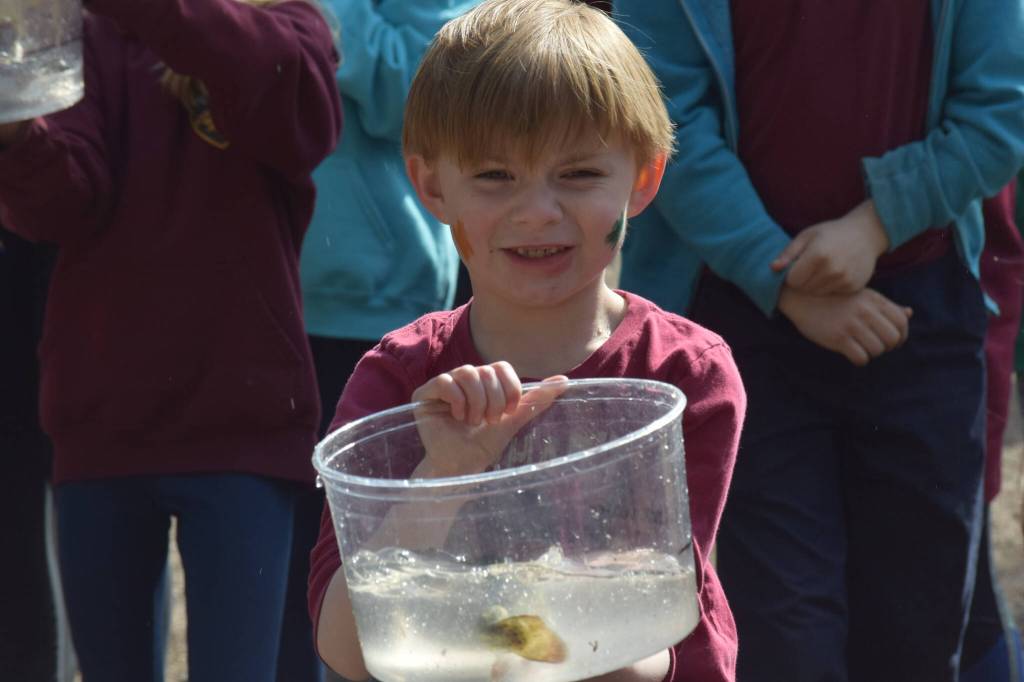 Archer Shack waits in line before releasing his rainbow trout at the 21st annual Kenai Peninsula Salmon Celebration in Kasilof on Wednesday, May 11, 2022. (Camille Botello/Peninsula Clarion)