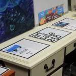 Placards display information and prices for art pieces up for auction as part of "ART Sale 258" at the Cook Inletkeeper Community Action Studio on Thursday, Dec. 9, 2021 in Soldotna, Alaska. (Ashlyn OHara/Peninsula Clarion)