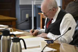Sen. Bert Stedman, R-Sitka, chair of the bicameral conference committee tasked with hammering out differences in the states budget bill, signs the committee report as members finished their work on Tuesday, May 17, 2022. (Peter Segall / Juneau Empire
