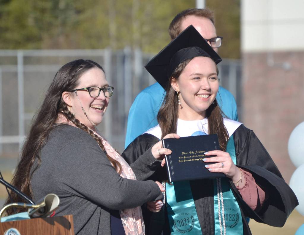 Dawn Edwards-Smith, principal at River City Academy, awards a diploma to Krystyana Kalugin on Tuesday, May 17, 2022, outside of Skyview Middle School just outside of Soldotna, Alaska. (Photo by Jeff Helminiak/Peninsula Clarion)