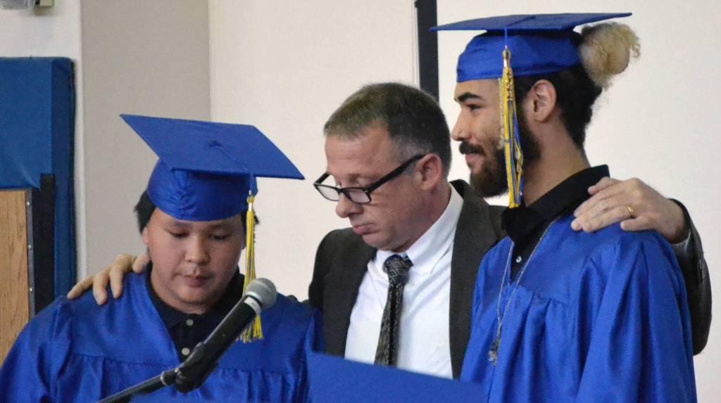 Armond Allain, II and Jack Doucet assist Loren Reese, the principal at Kenai Alternative High School, in the turning of tassels at the Kenai Alternative High Schools graduation ceremonies Wednesday, May 18, 2022, at the high school in Kenai, Alaska. (Photo by Jeff Helminiak/Peninsula Clarion)