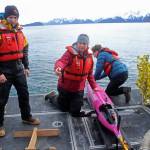 This May 4, 2022, photo shows oceanographers Andrew McDonnell, left, and Claudine Hauri, middle, along with engineer Joran Kemme after an underwater glider was pulled aboard the University of Alaska Fairbanks research vessel Nanuq from the Gulf of Alaska. The glider was fitted with special sensors to study ocean acidification. (AP Photo/Mark Thiessen)