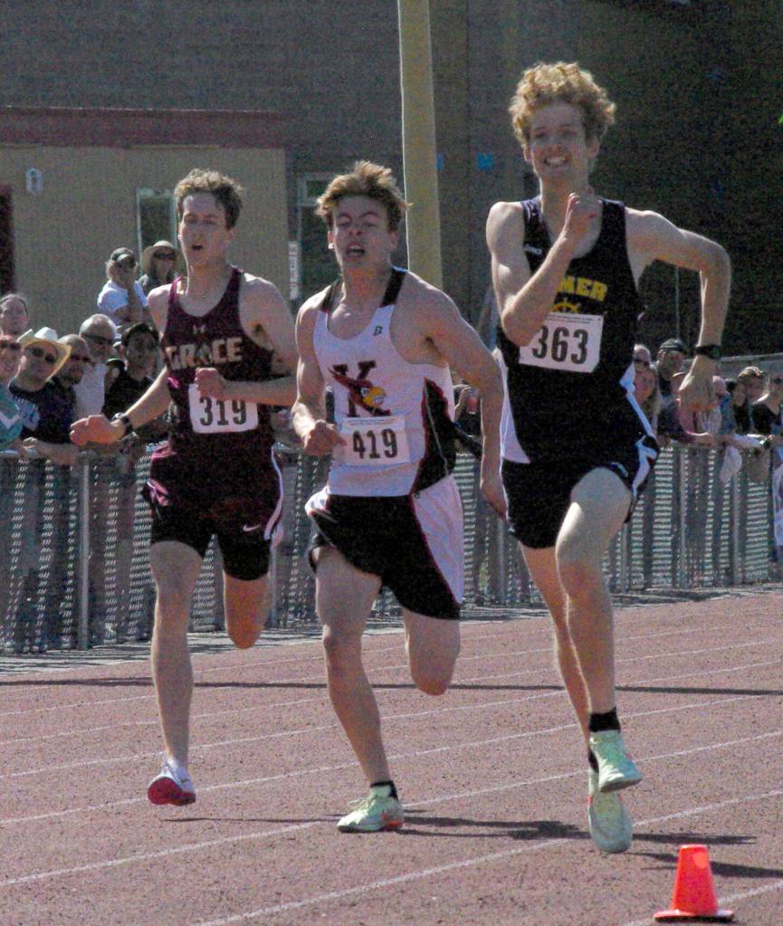Kenai Centrals Greg Fallon gets ready to pass Homers Seamus McDonough to win the boys Division II 800 meters Saturday, May 28, 2022, at the Division II state track and field meet at Dimond High School in Anchorage, Alaska. (Photo by Jeff Helminiak/Peninsula Clarion)