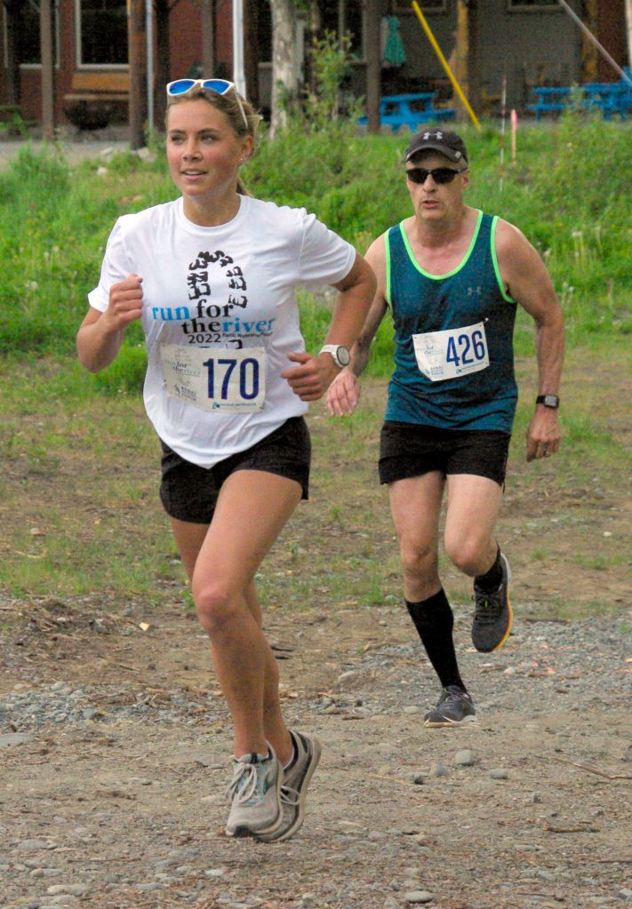 Jordan Strausbaugh, trailed by Ken Youngberg, runs to victory in the womens 5-kilometer race Saturday, June 11, 2022, at the Run for the River in Soldotna, Alaska. (Photo by Jeff Helminiak/Peninsula Clarion)