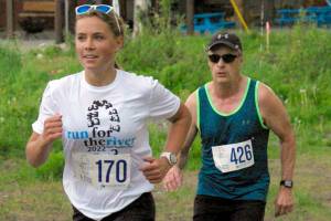 Jordan Strausbaugh, trailed by Ken Youngberg, runs to victory in the women's 5-kilometer race Saturday, June 11, 2022, at the Run for the River in Soldotna, Alaska. (Photo by Jeff Helminiak/Peninsula Clarion)