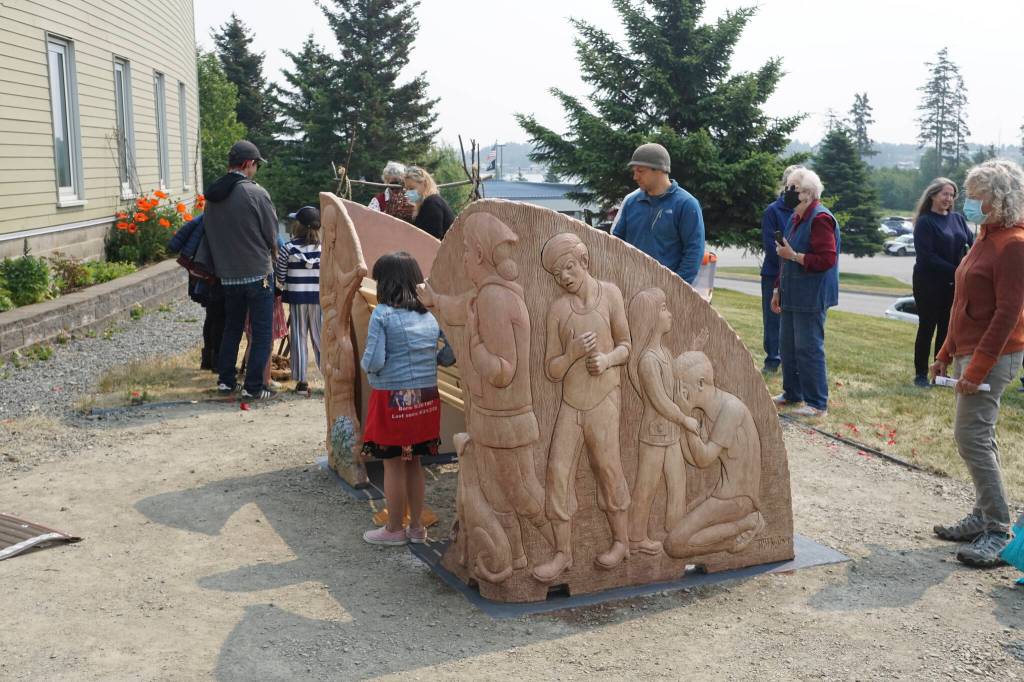 People visit at the Loved & Lost Memorial Bench on Sunday, June 12, 2022, at the Homer Public Library in Homer, Alaska, for a memorial for Anesha Duffy Murnane and the dedication of the bench. The girl by the bench wears a skirt honoring Florence Okpealuk, a Nome woman who went missing on Aug. 31, 2020, in Nome. (Photo by Michael Armstrong/Homer News)