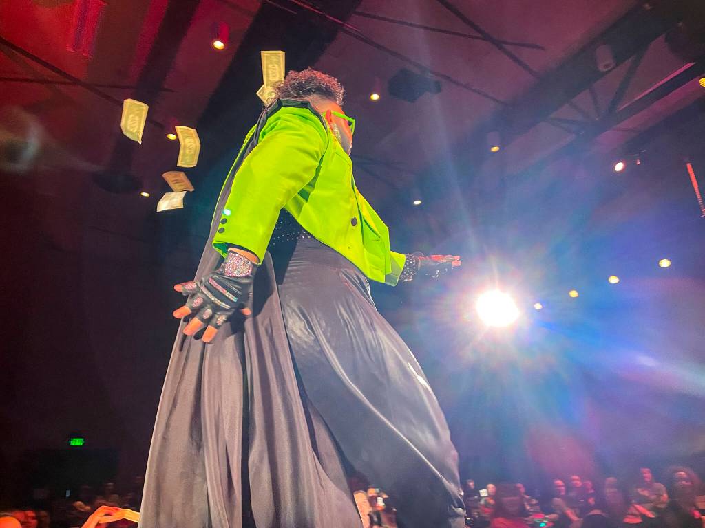 Tenderoni, one of the headliners, tosses off some of the dollar bills handed to them during Glitz, a major annual drag event celebrated every Pride Month, at Centennial Hall on June 18, 2022. (Michael S. Lockett / Juneau Empire)