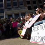 A crowd of people protesting near the Alaskan State Capitol clap at one of the many speakers at the protest, Saturday in Juneau. (Clarise Larson / Juneau Empire)