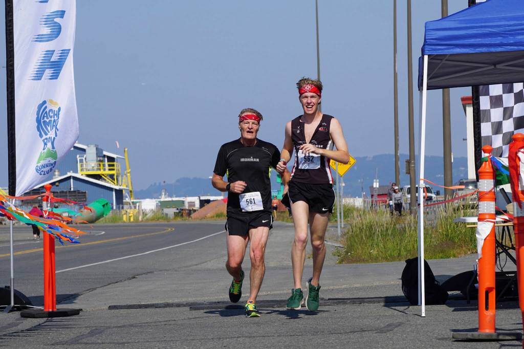Shaun Marshall-Pryde, left, and Stirling Marshall-Pryde, right, finish together the 2022 Homer Spit Run, on Saturday, June 25, 2022, at the End of the Road Park in Homer, Alaska. (Photo by Michael Armstrong/Homer News)