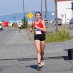 Kara Mickelson, the fourth-place woman in the 2022 Homer Spit Run Half Marathon, crosses the finish line on Saturday, June 25, 2022, at the End of the Road Park in Homer, Alaska. (Photo by Michael Armstrong/Homer News)