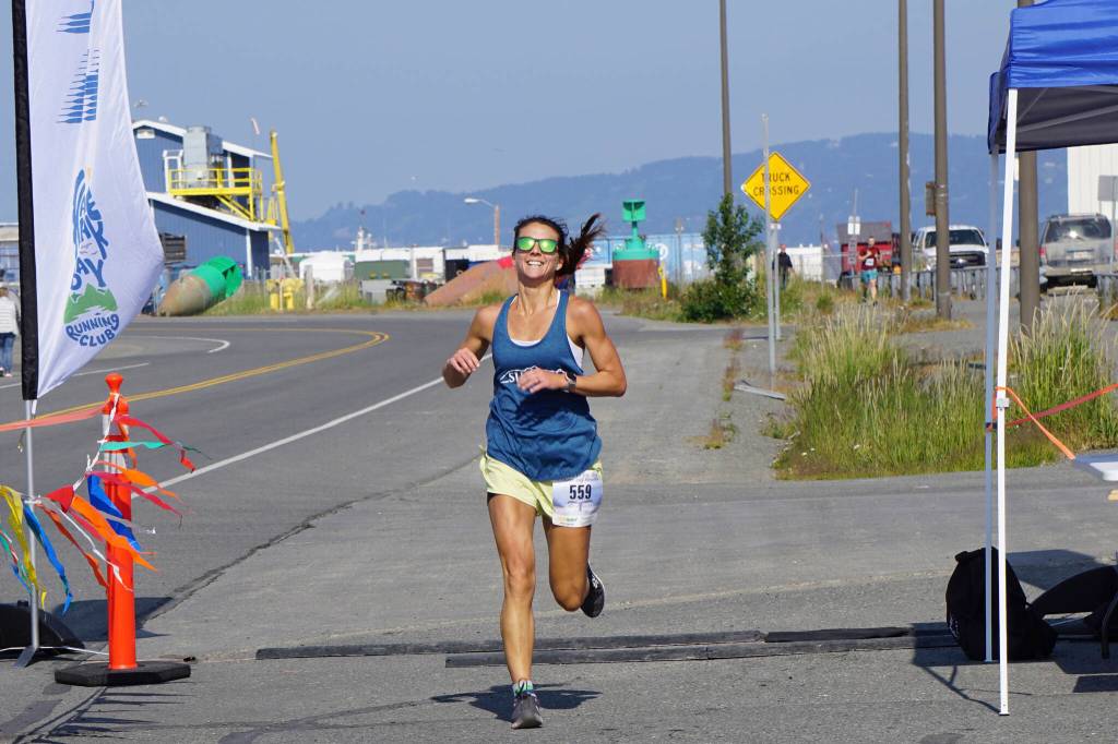 Amanda Cherok, the first-place woman runner in the 2022 Homer Spit Run, crosses the finish line on Saturday, June 25, 2022, at the End of the Road Park in Homer, Alaska. (Photo by Michael Armstrong/Homer News)