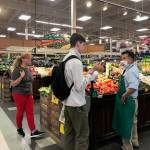 Iryna Hrynchenko and her 18 year old son Ivan, the first refugees from the war in Ukraine to arrive in Juneau, shop for produce at Fred Meyer while talking with an employee who arrived here as a refugee from Vietnam many years ago. (Courtesy Photo / Joyanne Bloom)