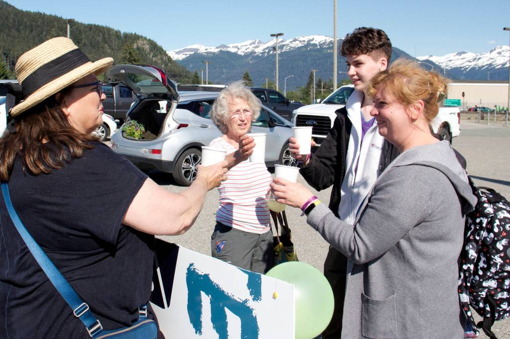 Iryna Hrynchenko and her 18 year old son, Ivan Hrynchenko, 18, Joyanne Bloom and Bridget Smith toast to the Ukrainians arrival Saturday, June 25, 2022, at Juneau Airport. Bloom and Smith are part of a five-person group of residents who raised funds to bring the Hrynchenkos to Juneau, and is helping them with housing, education and job opportunities, and in other ways. (Mark Sabbatini / Juneau Empire)