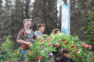 The cast of the Disney musical Tarzan, which is being performed at Soldotna Creek Park beginning Saturday, rides the Triumvirate Theatre float during the Kenai 4th of July Parade on Monday, July 4, 2022, in Kenai, Alaska. (Camille Botello/Peninsula Clarion)